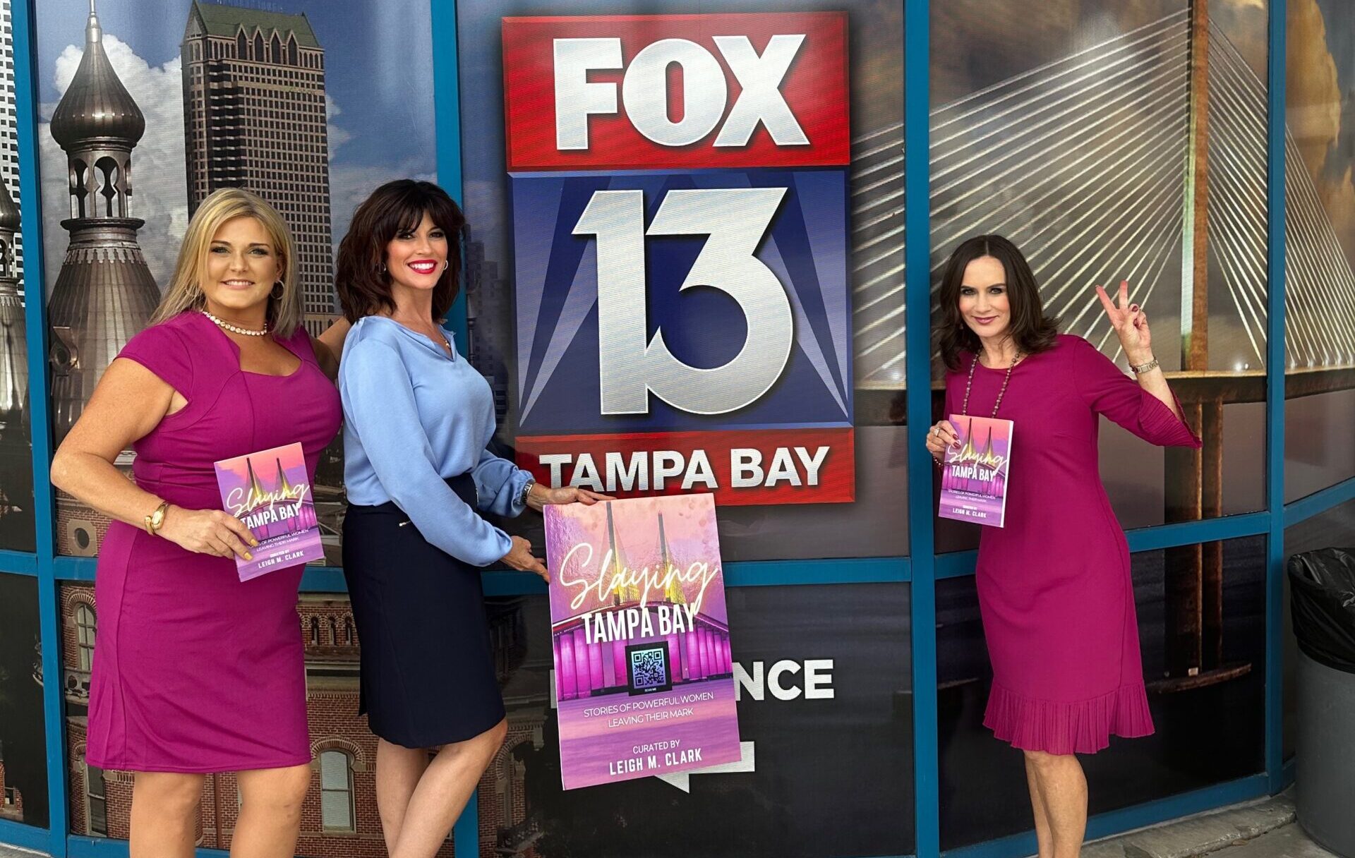 Three women standing in front of a building with a Fox 13 sign